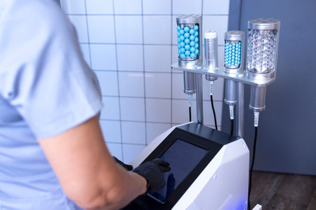 Faceless beautician using massager to remove fat from hips of customer in salon. Cosmetologist in a beauty salon. Cosmetologist dermatologist in a beauty clinic. cosmetic procedures.の写真素材