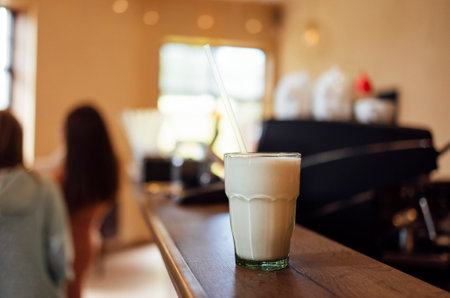 Glass with tasty vanilla milkshake on cafe or backgroundの写真素材