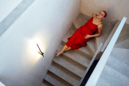Beautiful relaxed woman in red long dress and red shot hair looking good. concept of body positiveの写真素材