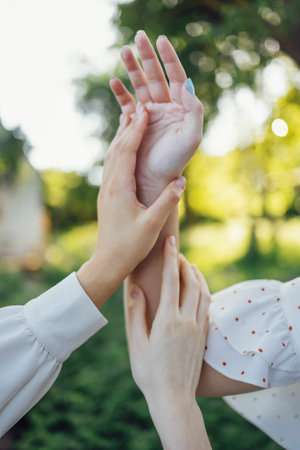 Close up of a women's hands touching the grass, feeling nature. beautiful green grass. The hands...