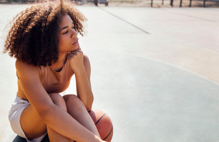 Mixed race young smiling female outdoors and having fun. Stylish cool teen girl gathering at basketball court, playing basketball outdoorsの写真素材