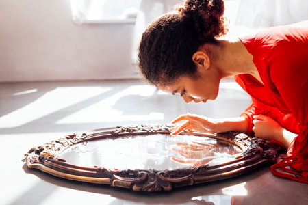 Portrait of attractive female african american looking in old mirror. Beautiful elegant afro girl in...
