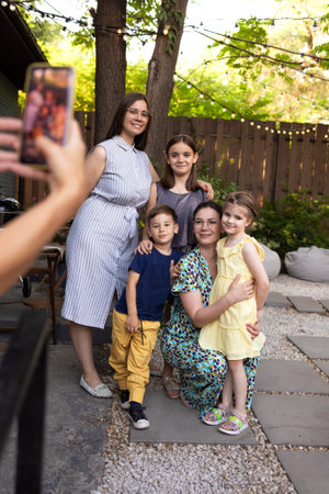 Happy family taking photo together using phone on vacation in the country. Young beautiful women...