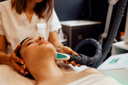 Lymphatic drainage massage LPG apparatus process. Therapist beautician makes a rejuvenating facial massage for the model in a beauty salon. Close up, selective focusの写真素材
