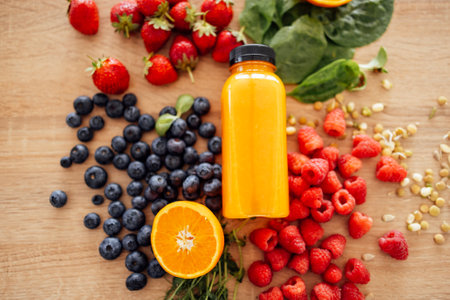 Citrus fruits, berries, greens, sprouted beans and bottle of orange juice on the background of a wooden table. Heart gesture. View from above. Healthy food and drinks concept.の写真素材