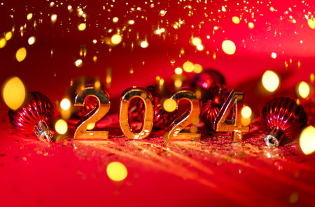 2024 gold colored numbers and glittering confetti on a vivid bright red background. New Year composition. Text background. New year and business concept strategyの写真素材