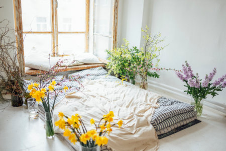 Minimalistic retro bedroom interior. Mattresses, pillows and a bedspread on the floor near the huge...
