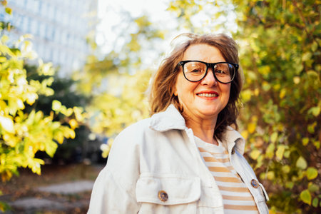Smiling middle aged woman in casual clothers looking at camera. Happy old lady in glasses posing at...