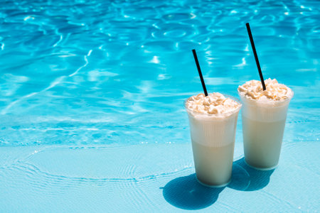 Two glasses with a tasty chilled cocktail. Milkshake with whipped cream. Delicious fresh drink by...