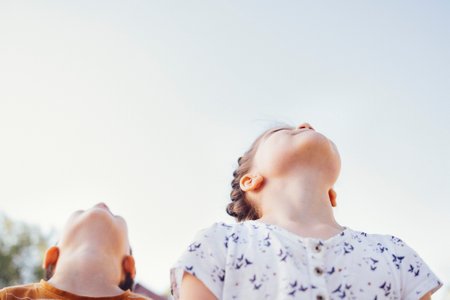Little cute kids in casual clothes hug each other tightly. Happy girl and boy are smiling and...