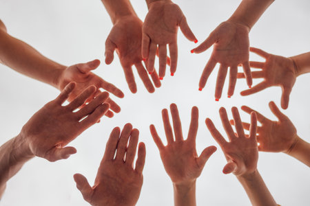 Female and male hands on a white background. The arms of men and women in a circle on a light...