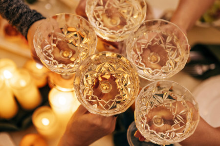 Close-up of male and female hands with elegant champagne glasses. Men and women toast with goblets of sparkling wine. Friends click glasses with alcoholic drinks. A party or a meeting of friends.の写真素材