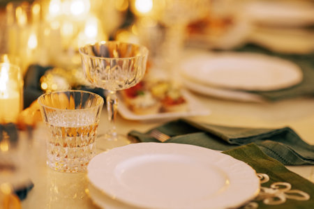 A cozy stylish living room with a covered table and a decorated Christmas tree with a garland. A...