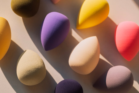 Colorful makeup sponges on a light background. A set of soft bright sponges in the form of a drop in the sunlight. Cosmetic productsの写真素材