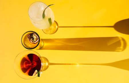 Close-up of three different delicious multicolored drinks. Glasses with tasty cocktails on a beige background. Fresh fruit drinks with ice. Sunlight. Minimalism. Copy spaceの写真素材