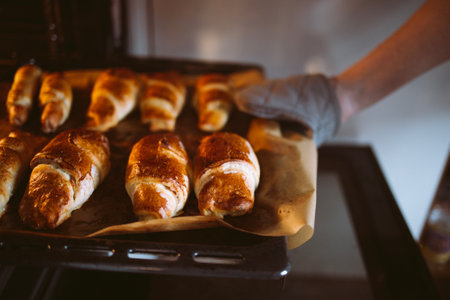 Close-up of delicious mouth-watering hot croissants on a baking sheet from the oven. Delicious sweet pastries on parchment paper. Homemade handmade cakesの写真素材