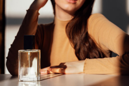 A young girl has closed her eyes and is enjoying the scent of perfume. A teenager in casual clothes...