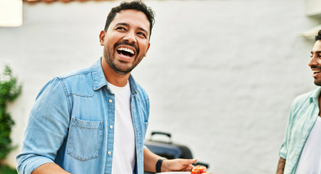 Happy man in denim shirt is enjoying time with friends outdoors, holding food, surrounded by greenery, creating a warm and inviting social atmosphere, AI generatedの素材