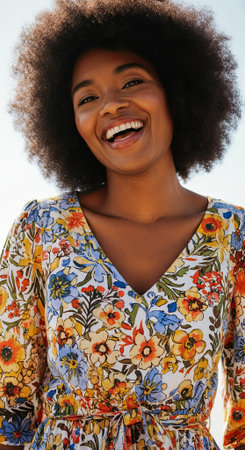 Happy female with an afro hairstyle, dressed in a floral print dress, enjoys a sunny day outdoors, exuding positivity and a cheerful vibe in a lively setting, AI generatedの素材