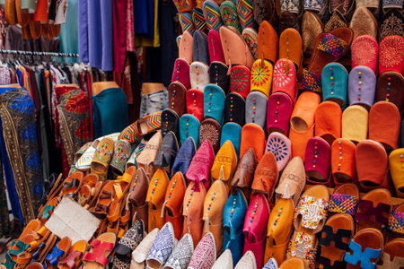 Handcrafted footwear in various colors and designs is displayed in a lively market, highlighting unique textures and cultural artistry, ideal for fashion inspirationの写真素材