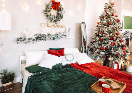 Bedroom adorned for New Year with a beautifully decorated tree, colorful blankets on the bed, and a festive wreath, evoking a cheerful holiday spiritの写真素材