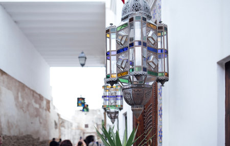 Vibrant lanterns adorn a narrow alleyway, featuring intricate glass designs and casting warm light, enhancing the charming atmosphere of the architectural spaceの写真素材