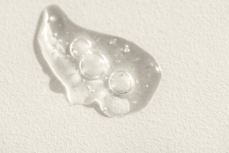 Extremely close-up view of a transparent gel with bubbles and colloidal gold. Cosmetic products. A...