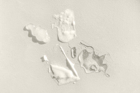 Different texture of gel and cream on a yellow background. Transparent and white serum with drops. The consistency of glycerin gel.の写真素材