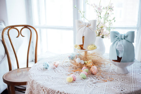 Easter-themed table display with pastel eggs and floral decor, showcasing two cake stands adorned...