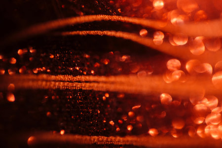 Close-up view of red fabric displaying rich textures and a soft bokeh effect, highlighting the play of light and shadow in the intricate detailsの写真素材