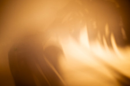 Abstract image featuring warm golden hues and blurred light patterns, creating a smooth gradient...