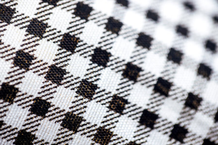 Close-up of black and white checkered fabric displaying a traditional plaid pattern, highlighting...