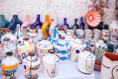 A collection of colorful ceramic vases with artistic patterns is displayed on a table, highlighting unique craftsmanship and vibrant colors in an artistic arrangementの写真素材
