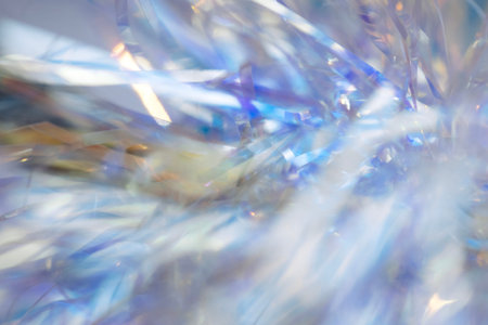 Close-up view of shimmering blue and silver tinsel strands, creating an abstract and colorful background ideal for festive themes and design projects