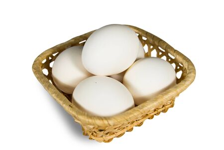 chicken eggs in basket on white backgroundの写真素材