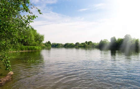 lake with green trees and blue sky