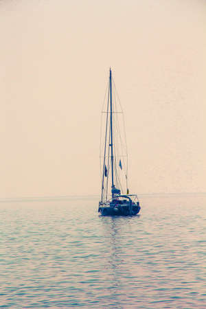 Vacation boat in open sea on rose sunsetの写真素材