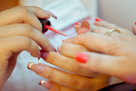 Manicure process with fingers and coral nailの写真素材