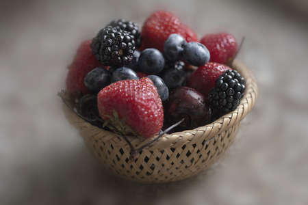 Multicolour berries from fresh strawberry and blackberry in basketの写真素材