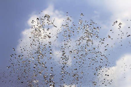Spray fountain against blue sky in sunny dayの写真素材