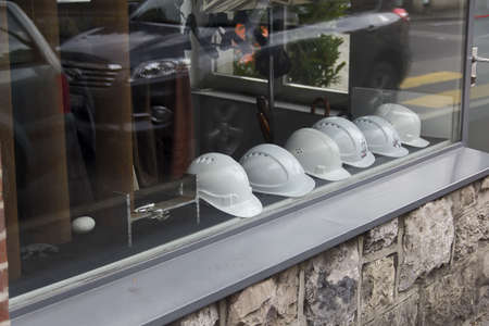 Shop window with white helmets at cloudy day