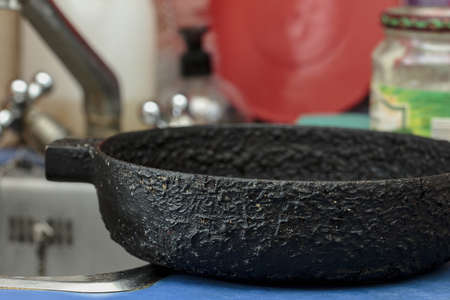 Old cast iron black skillet in kitchenの写真素材