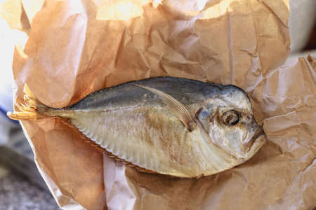 Nice grey yellow dried fish on light brown paper