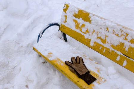 Brown forgotten glove on snowy branch at winterの写真素材