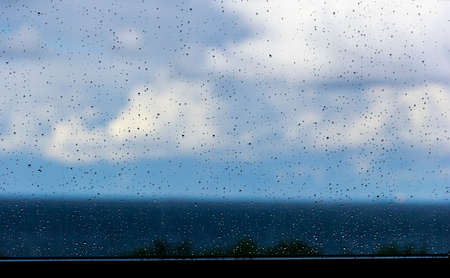 Drops on glass after rain on background of blue skyの写真素材