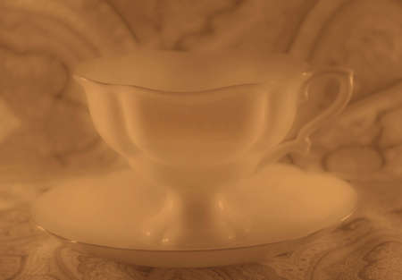 Nice white porcelain cup with saucer in sepiaの写真素材