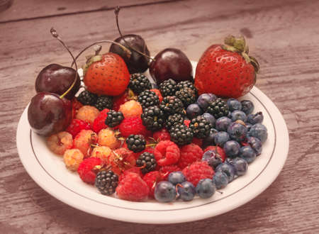 Nice fresh different berries on white plateの写真素材