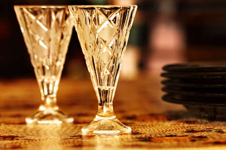 Two nice vodka shot glasses on table in golden colorsの写真素材