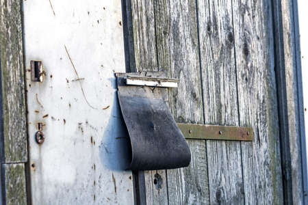 Padlock under rubber flap on old abandoned barnの写真素材