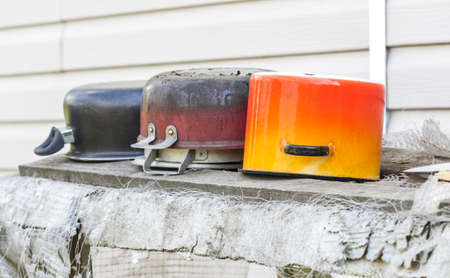Old four colorful cooking pots on grey backgroundの写真素材